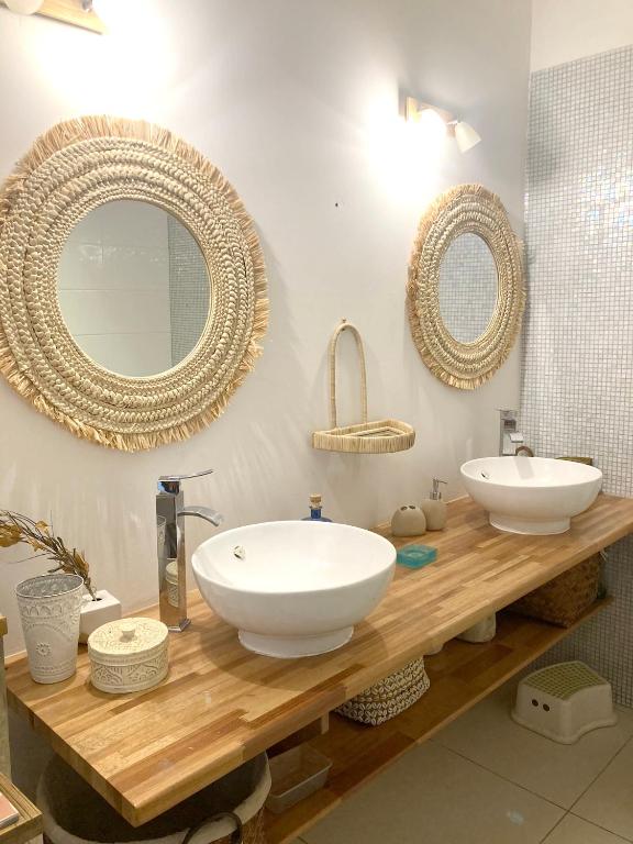 a bathroom with two sinks and mirrors on a wooden counter at Maison de 3 chambres avec jardin clos et wifi a Saint Denis in Saint-Denis