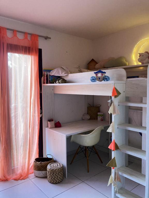 a bunk bed with a desk and a chair in a room at Maison de 3 chambres avec jardin clos et wifi a Saint Denis in Saint-Denis