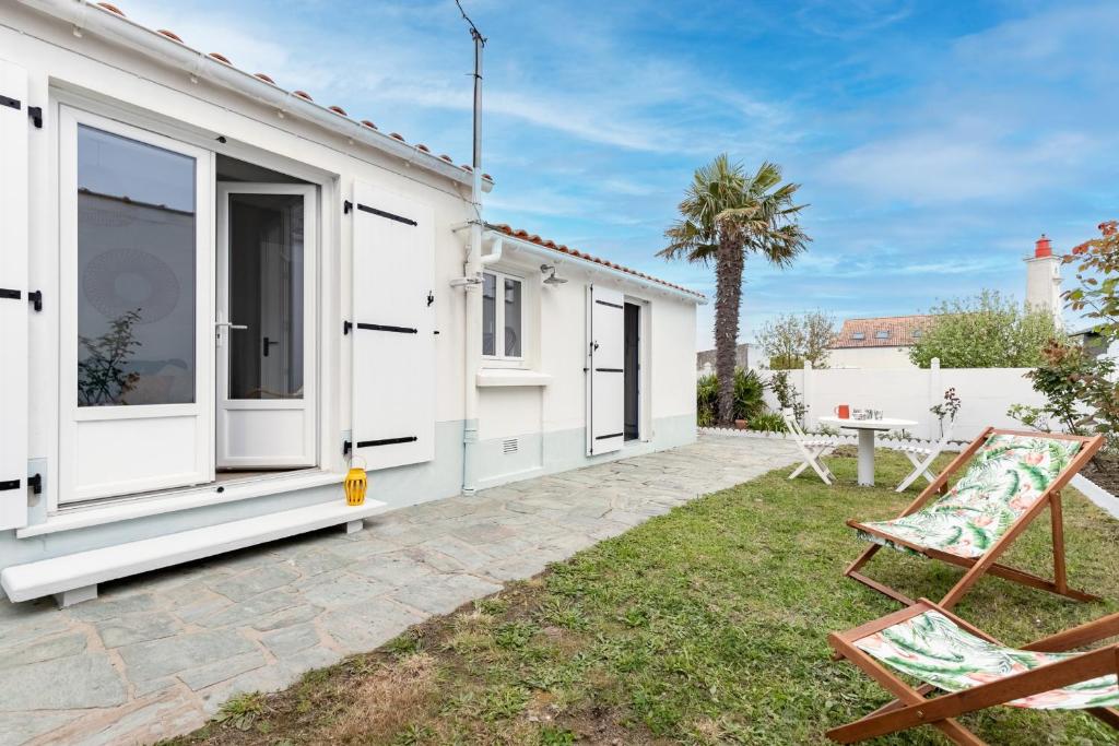 a house with a patio and a palm tree at L'Argentine, Maison typique pour 5 a Saint Gilles-croix-de-vie in Saint-Gilles-Croix-de-Vie