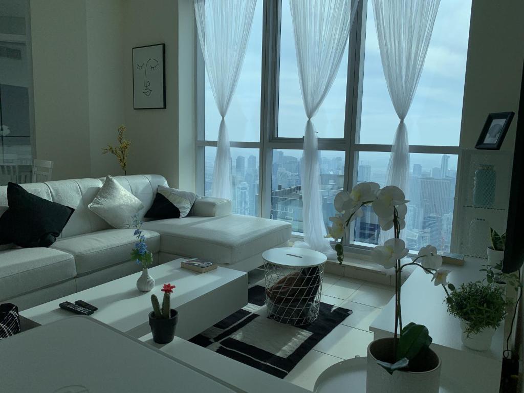 a living room with a white couch and a large window at Torch 77 in Dubai