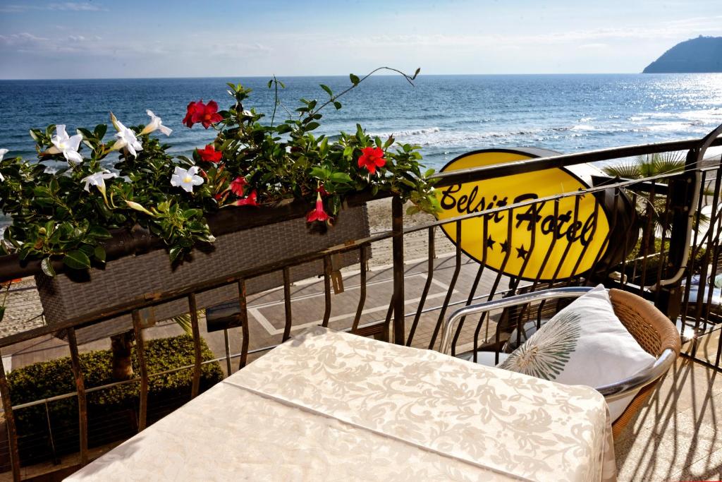 un tavolo e sedie su un balcone con vista sull'oceano di Hotel Bel Sit ad Alassio