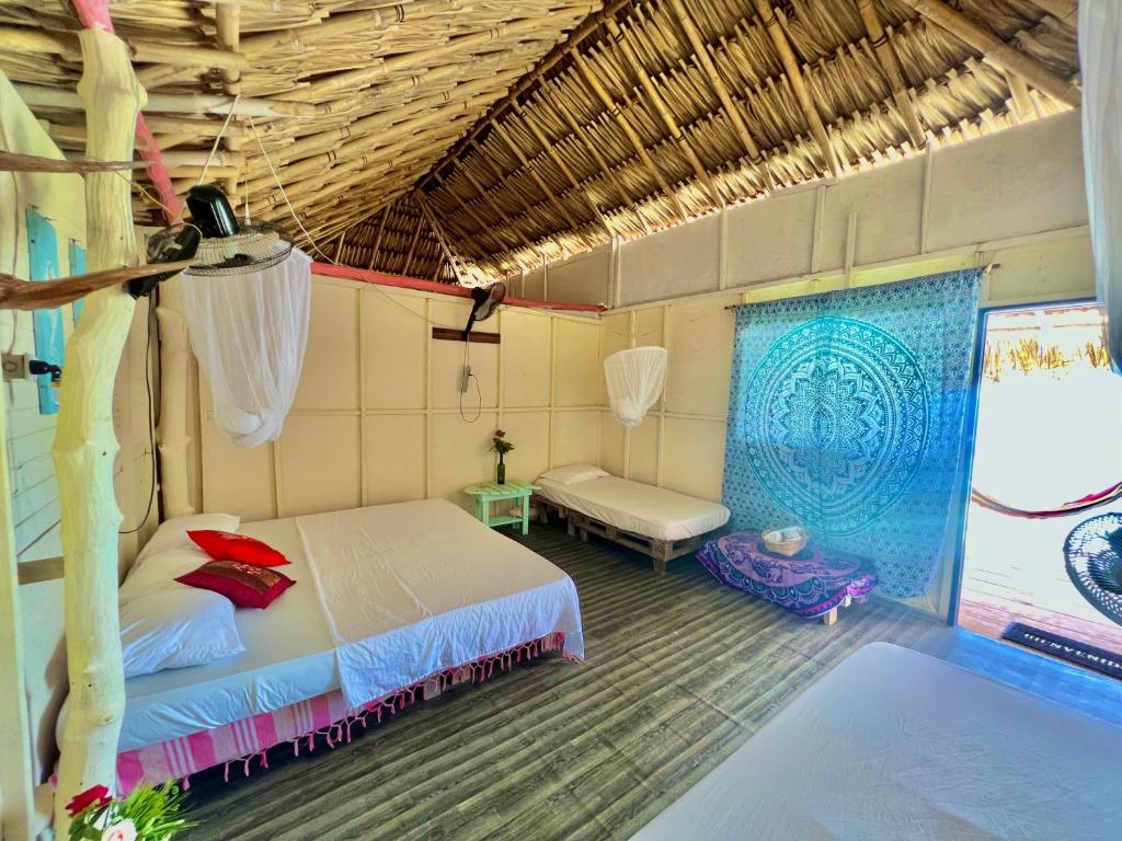 a bedroom with a bed and a couch in a room at Tintipan Ashram Hostel & Glamping in Tintipan Island