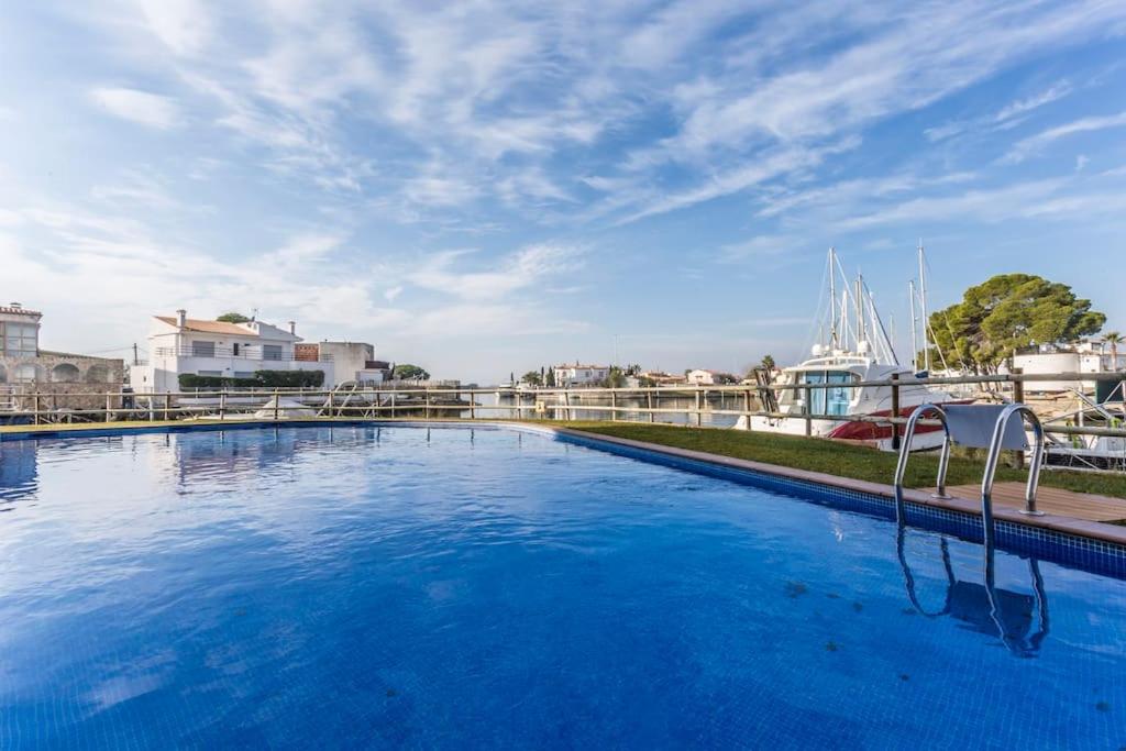 una gran piscina azul con una silla blanca en Piso de 2 habitaciones, 3 piscinas y cerca del mar en Rosas