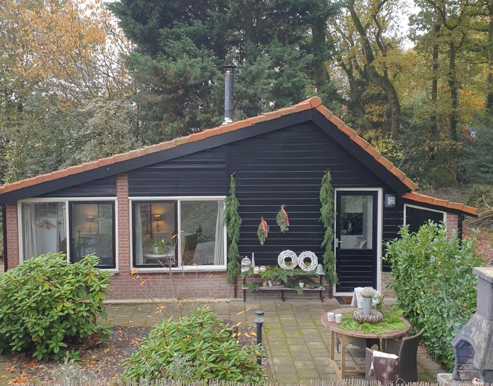 a small black house with a patio in front of it at BenB Op de Vleet in Centrum