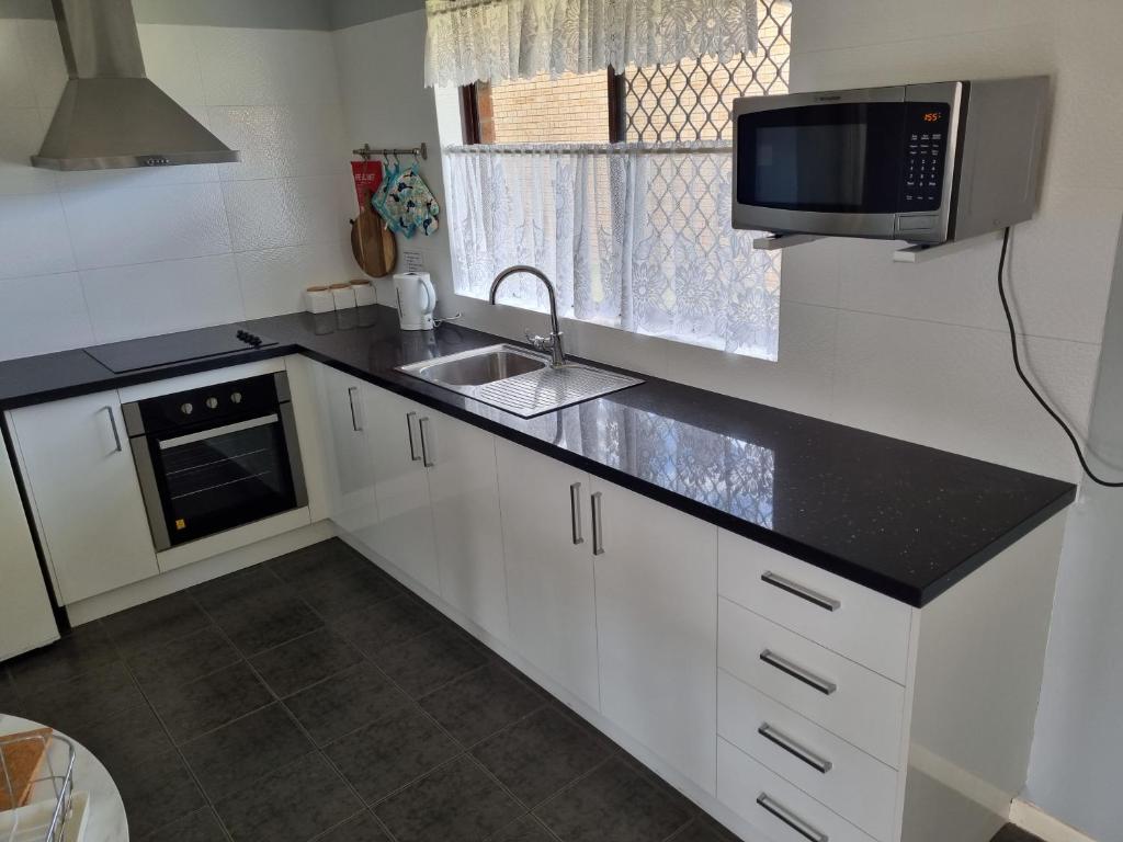 a kitchen with a sink and a microwave at Ocean Beach Chalet 18 in Jurien Bay