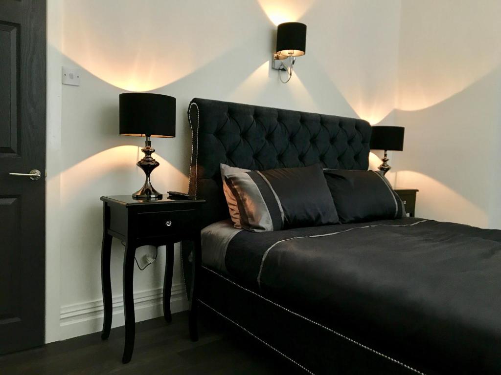 a bedroom with a black bed with a black headboard at 77 Park Road Apartments in Blackpool