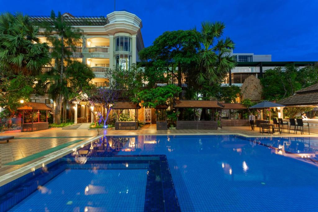 una piscina frente a un edificio por la noche en Somadevi Angkor Premium, en Siem Reap