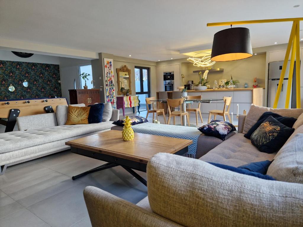 een woonkamer met banken en een tafel en een keuken bij Magnifique Villa de luxe POPPY HOLIDAY À 2 mn à pied de la plage, mer, jardin, Jaccuzi & Baby-foot in Ouistreham
