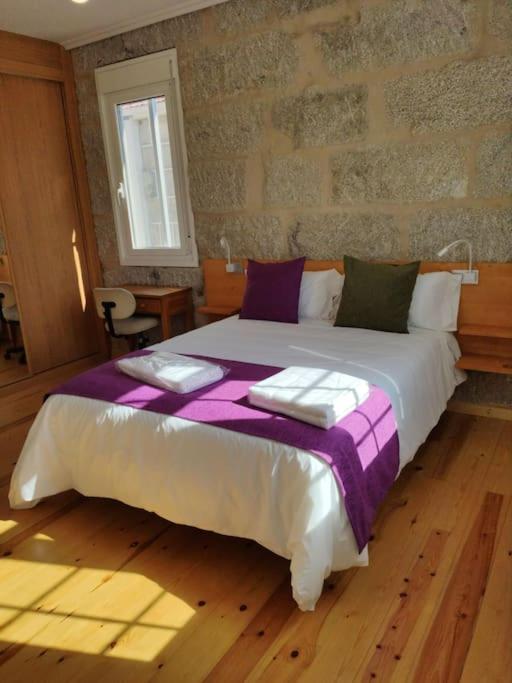 A bed or beds in a room at Casa Carmiña: Casa para pequeños grupos en el corazón de Galicia
