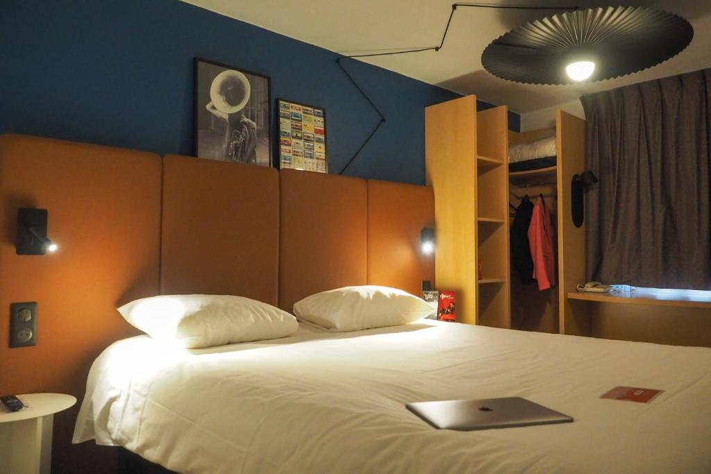 a bedroom with a bed with a laptop on it at ibis Douai Centre in Douai