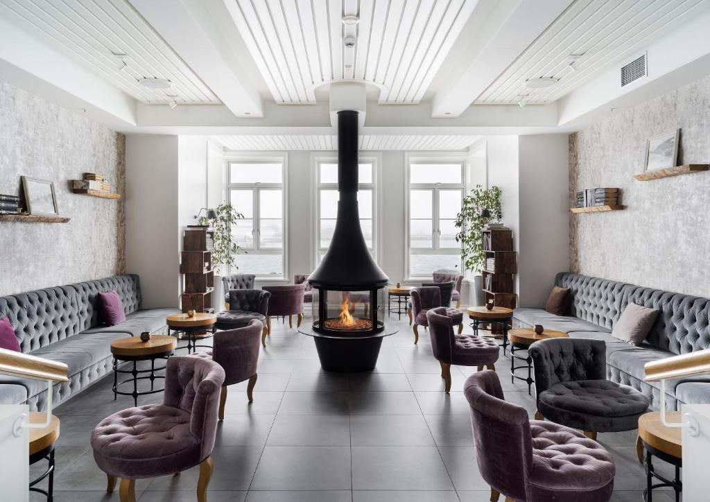 a restaurant with a fireplace and chairs and tables at Siglo Hotel by Keahotels in Siglufjörður