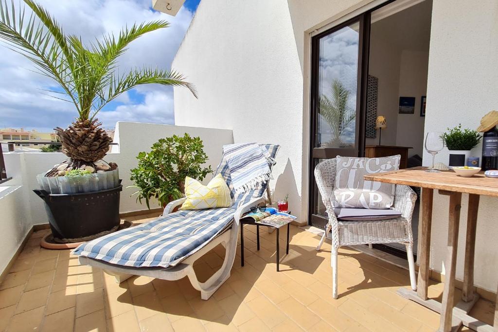 een balkon met een bank en een tafel en stoelen bij Sunny Apart W Balcony in Algarve by LovelyStay in Ferragudo