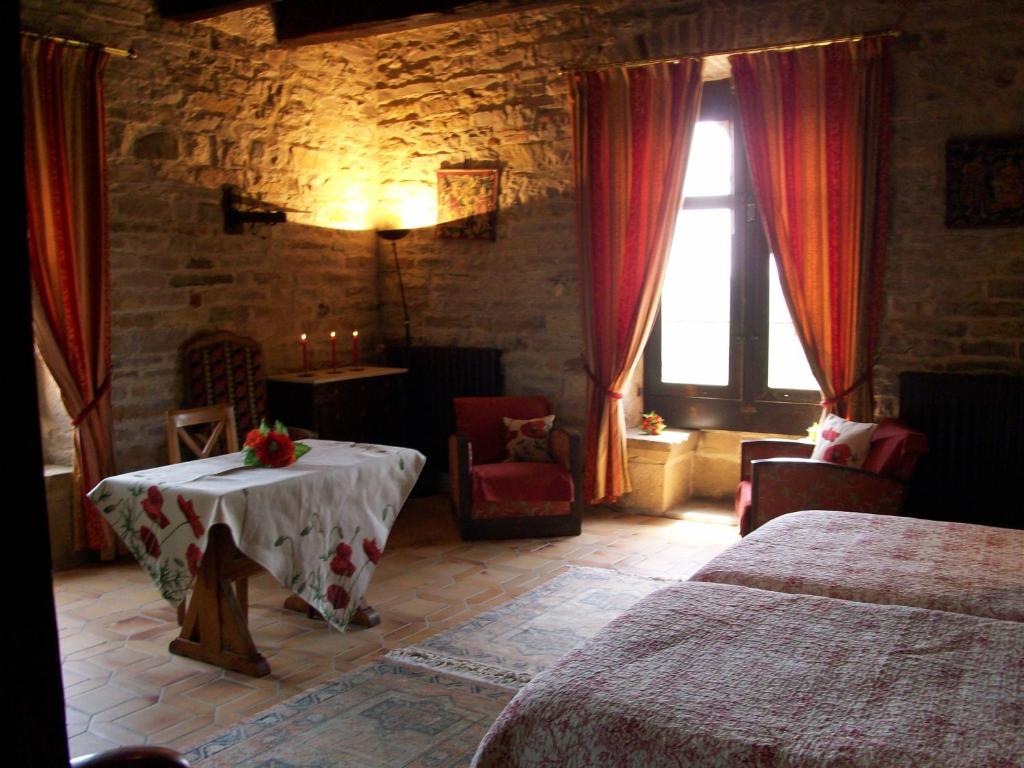 une chambre avec deux lits et une table et une fenêtre dans l'établissement Auberge de La Halle, à Cordes-sur-Ciel