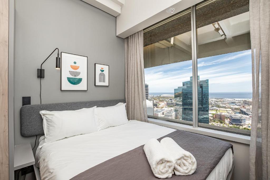 a bedroom with a bed and a large window at One Thibault Apartments by ITC Hospitality in Cape Town
