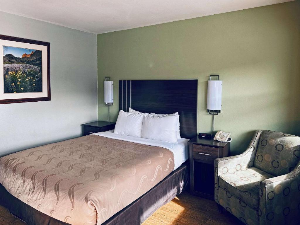 Quality Inn Durango في دورانجو: غرفه فندقيه بسرير وكرسي