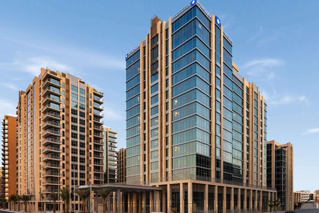 un edificio alto con ventanas de cristal en una ciudad en Wyndham Dubai Deira en Dubái