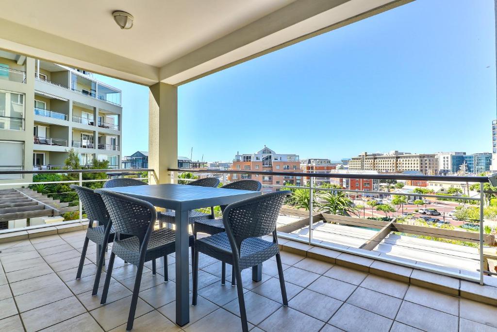 a table and chairs on a balcony with a view at Luxury three Bedroom Apartment - fully furnished and equipped in Cape Town