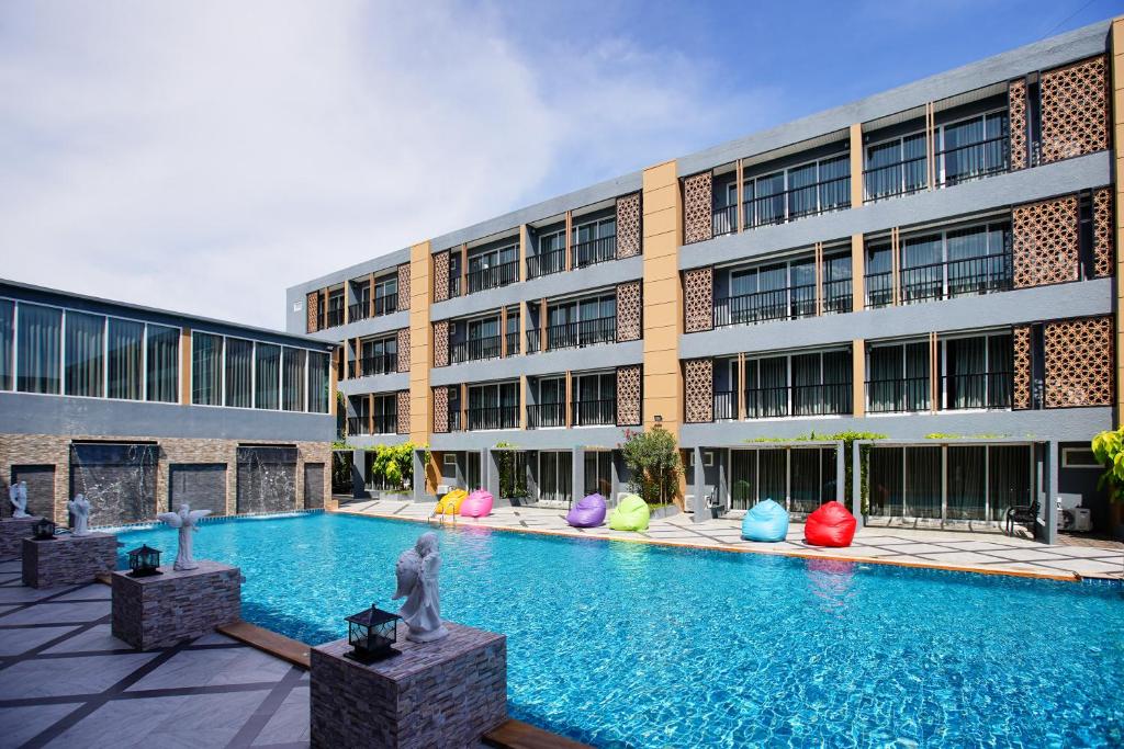 a swimming pool in front of a building at Golden Sea Hua Hin - SHA Extra Plus in Hua Hin