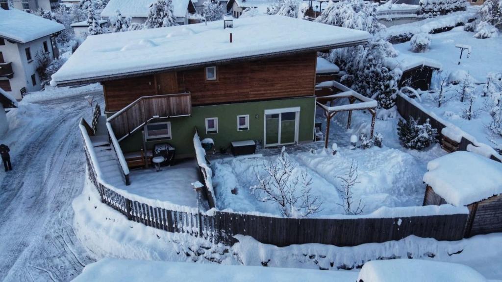 ein schneebedecktes Haus mit einem Hof in der Unterkunft Freestyle Apartment in Sautens