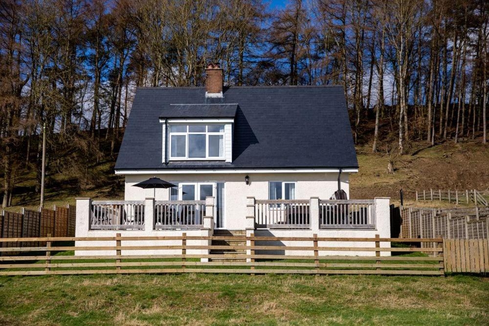 a white house with a fence in front of it at Lower Pentre in Llanddewi Ystradenny