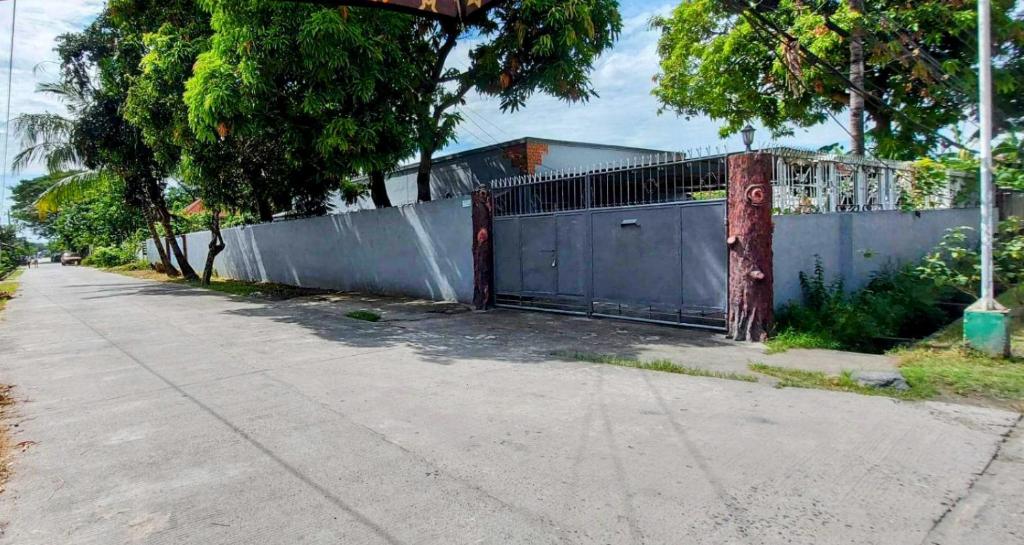 a gate on the side of a road next to a fence at 5bedroom Home with Parking in Tarlac