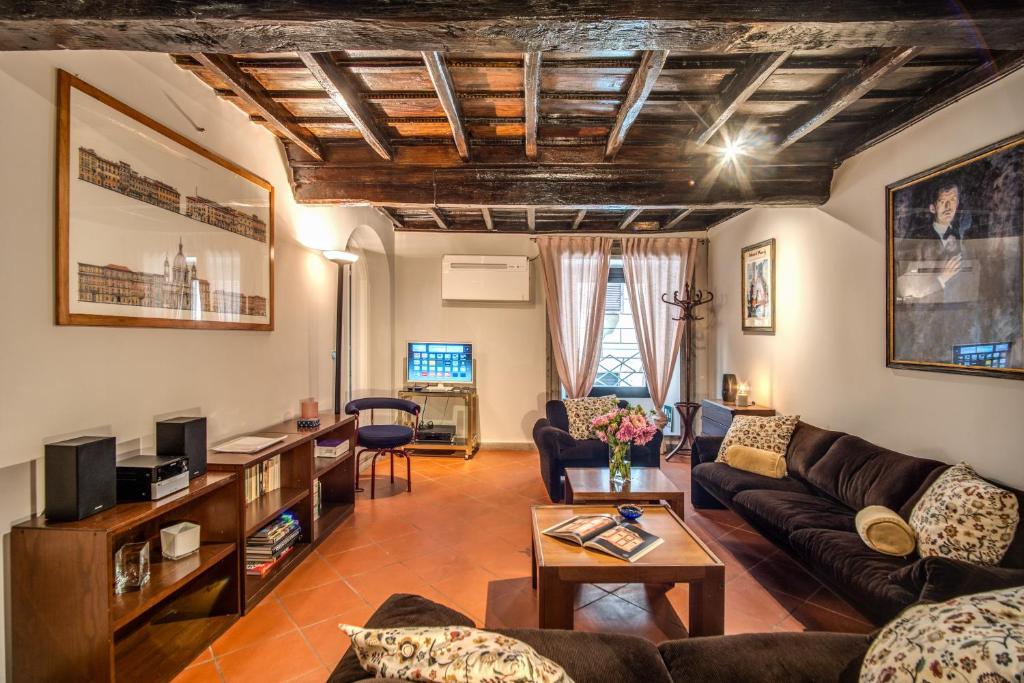 uma sala de estar com um sofá e uma mesa em Cartari Apartment em Roma