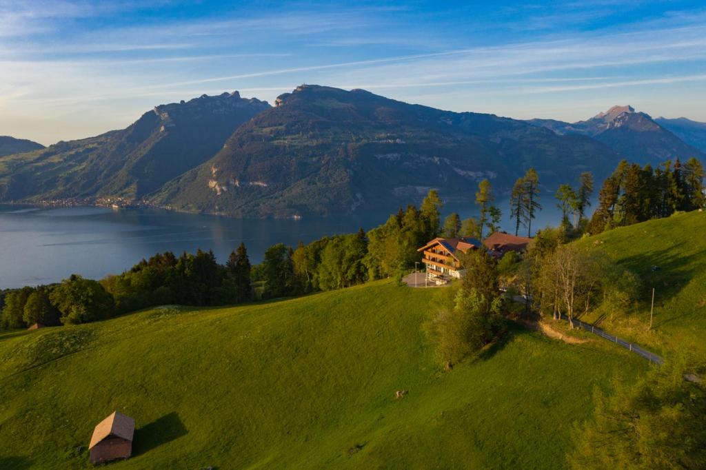 una casa su una collina con un lago e montagne di Auszeit-Hotel Z Aeschiried ad Aeschi