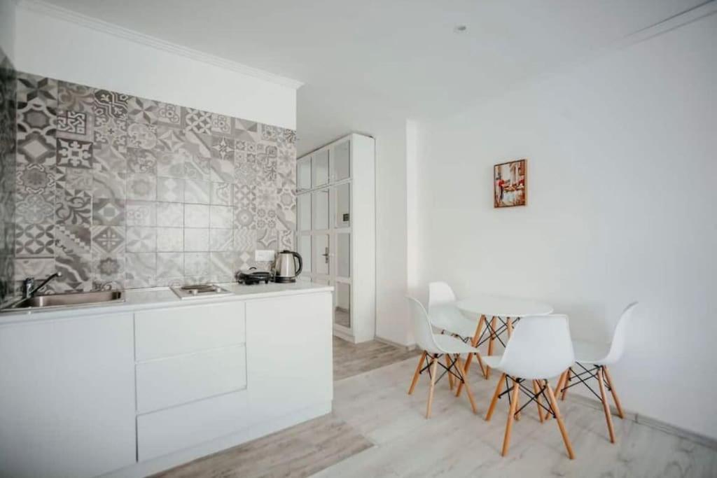 a kitchen with white cabinets and a table and chairs at Ultra Lux in New Gudauri in Gudauri