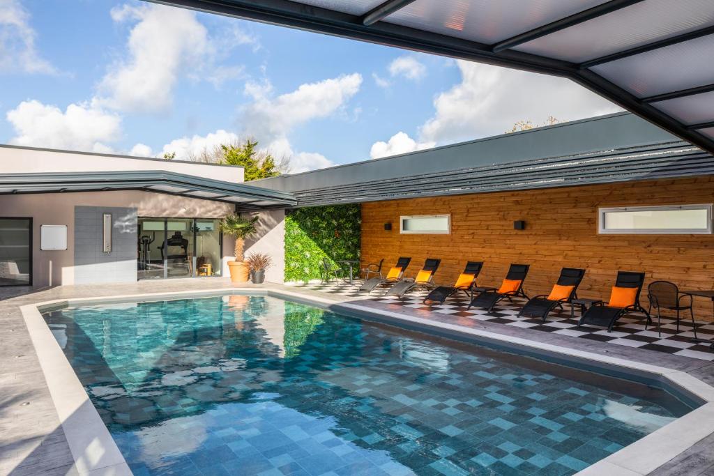 an indoor pool with chairs and a house at ibis Saint-Nazaire - Trignac in Trignac