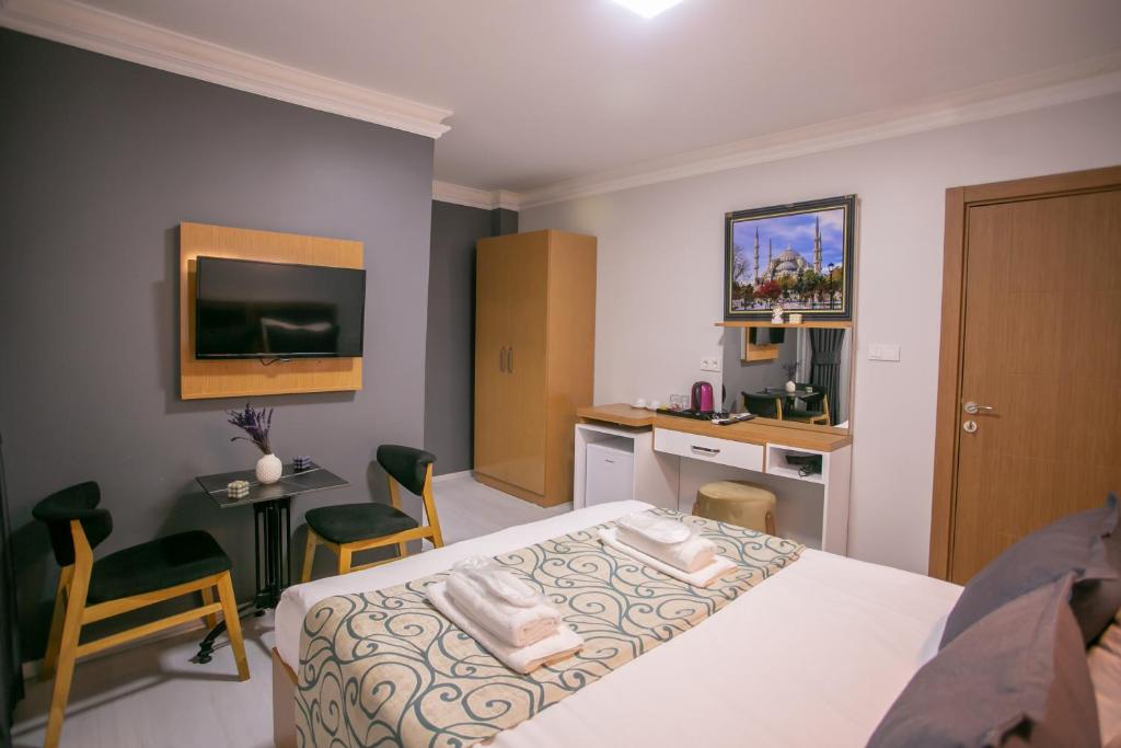 a bedroom with a bed and a table and a kitchen at BLAU GRÜN İSTANBUL OTEL in Istanbul