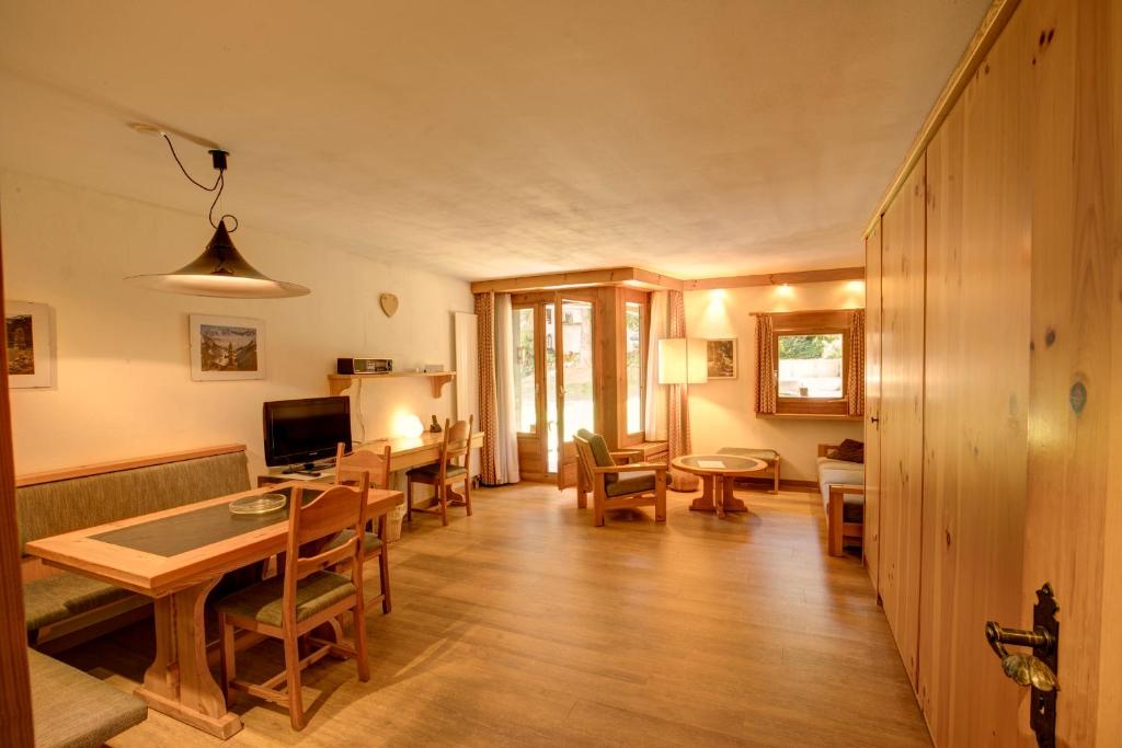 a living room with a table and a dining room at Chesa Munteratsch 1-Zimmerwohnung 107 Typ B in Silvaplana