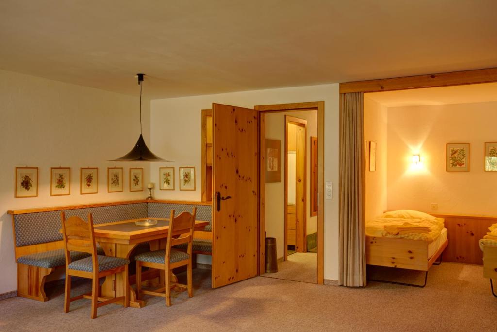 um quarto com uma mesa e cadeiras e um quarto em Chesa Munteratsch 1 1 2-Zimmerwohnung 204 Typ D em Silvaplana