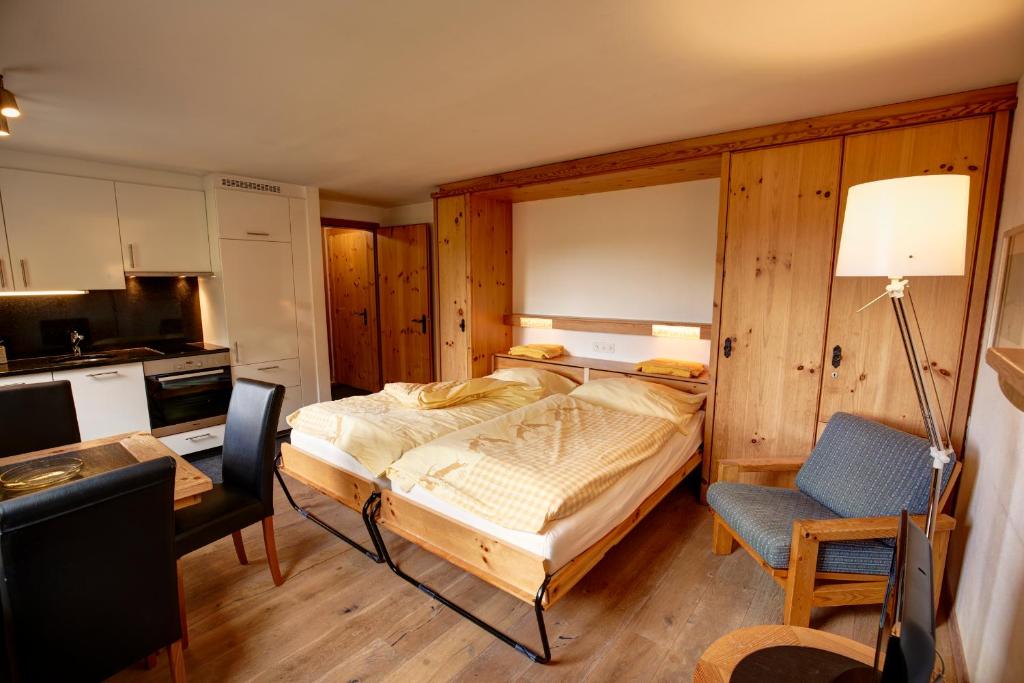 Schlafzimmer mit einem Bett, einem Schreibtisch und einem Stuhl in der Unterkunft Chesa Munteratsch 1-Zimmerwohnung 411 Typ A in Silvaplana