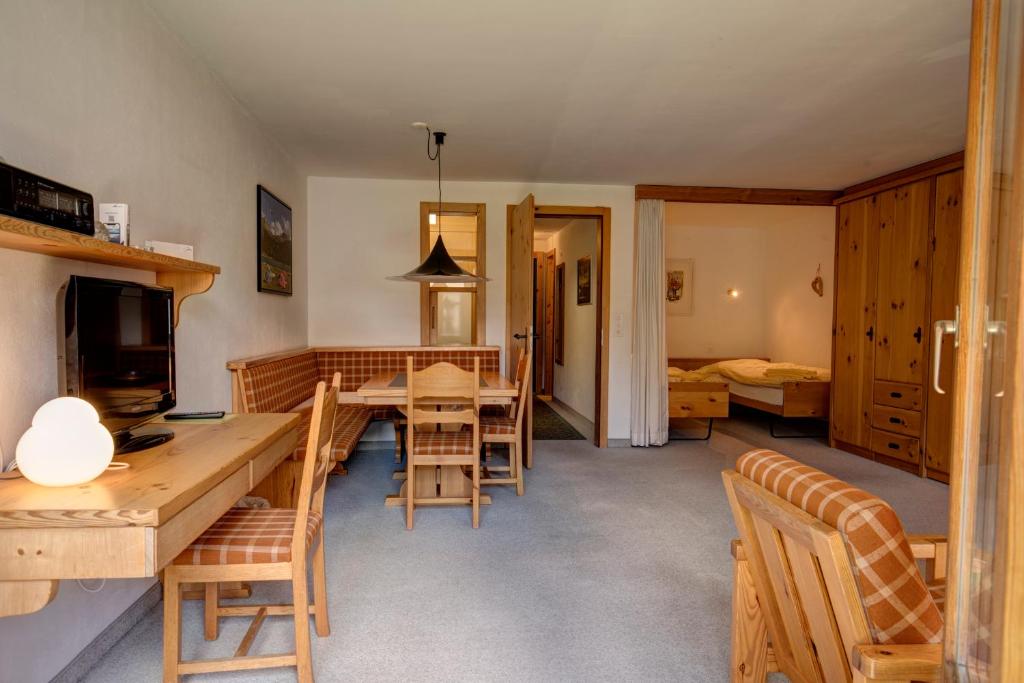 eine Küche und ein Esszimmer mit einem Tisch und Stühlen in der Unterkunft Chesa Munteratsch 1 1 2-Zimmerwohnung 509 Typ D in Silvaplana