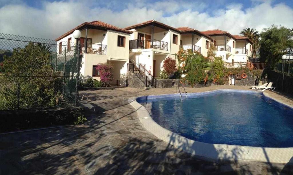 a villa with a swimming pool in front of a house at Chijere San Sebastián in San Sebastián de la Gomera