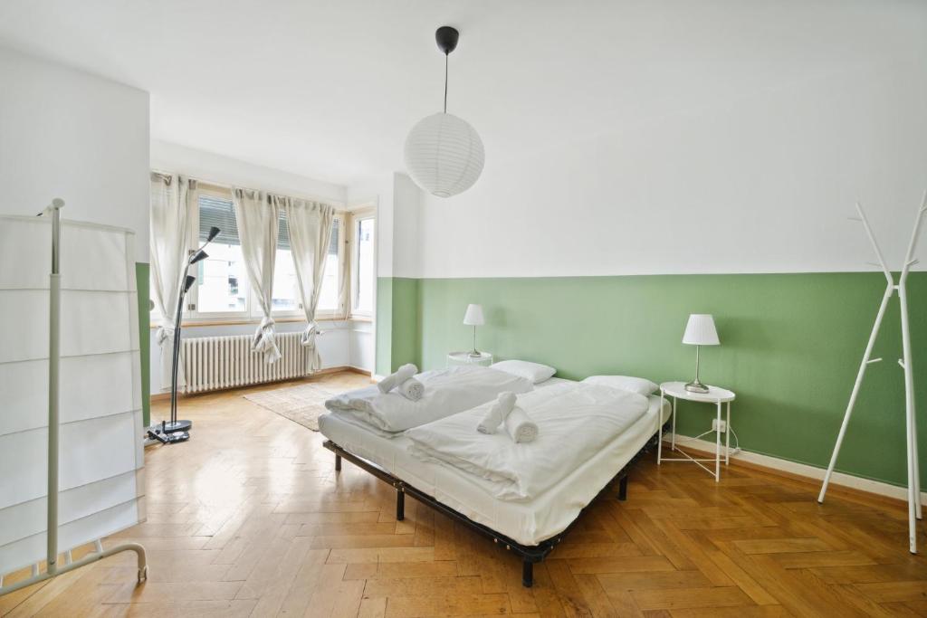um quarto com uma cama e uma parede verde em Central Apartment for City Explorers 222 em Zürich