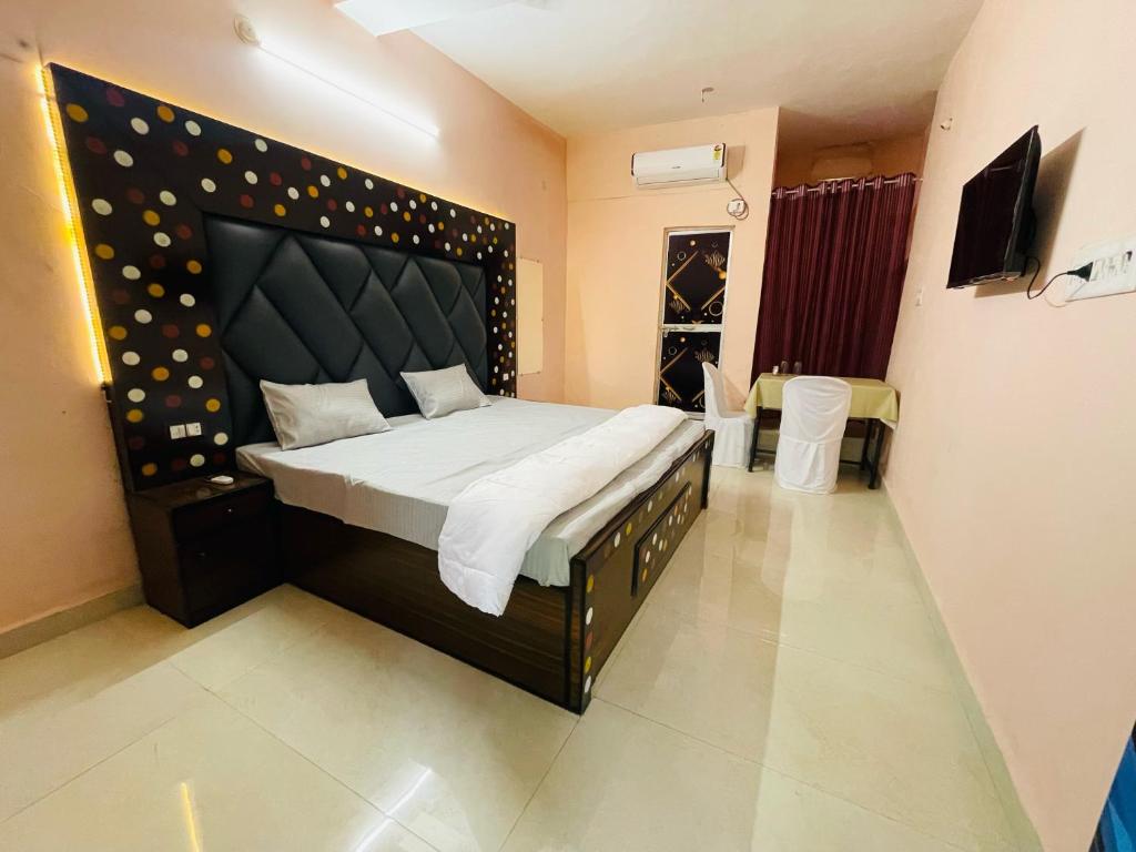 a bedroom with a large bed with a large headboard at Hotel green park in Jabalpur