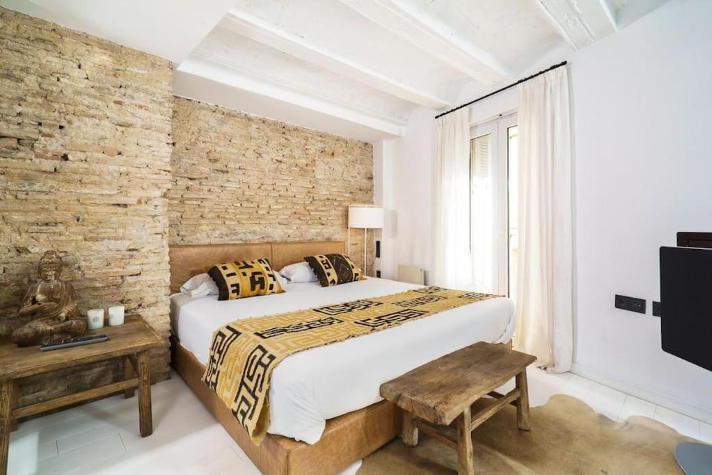 een slaapkamer met een groot bed en een bakstenen muur bij Valencia Luxury - Boutique El Carmen in Valencia