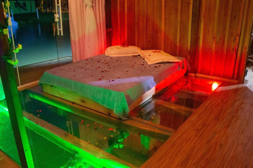 1 cama en una habitación junto a una pecera en Cabana Casa do Lago, en Ilha Grande