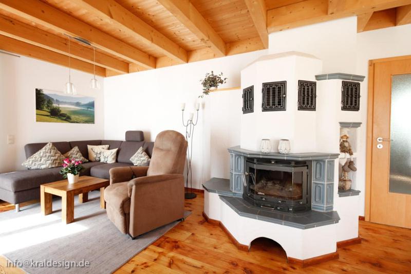 a living room with a fireplace and a couch at Sonnige Ferienwohnung, Rollstuhlgerecht, Hunde willkommen in Isny im Allgäu