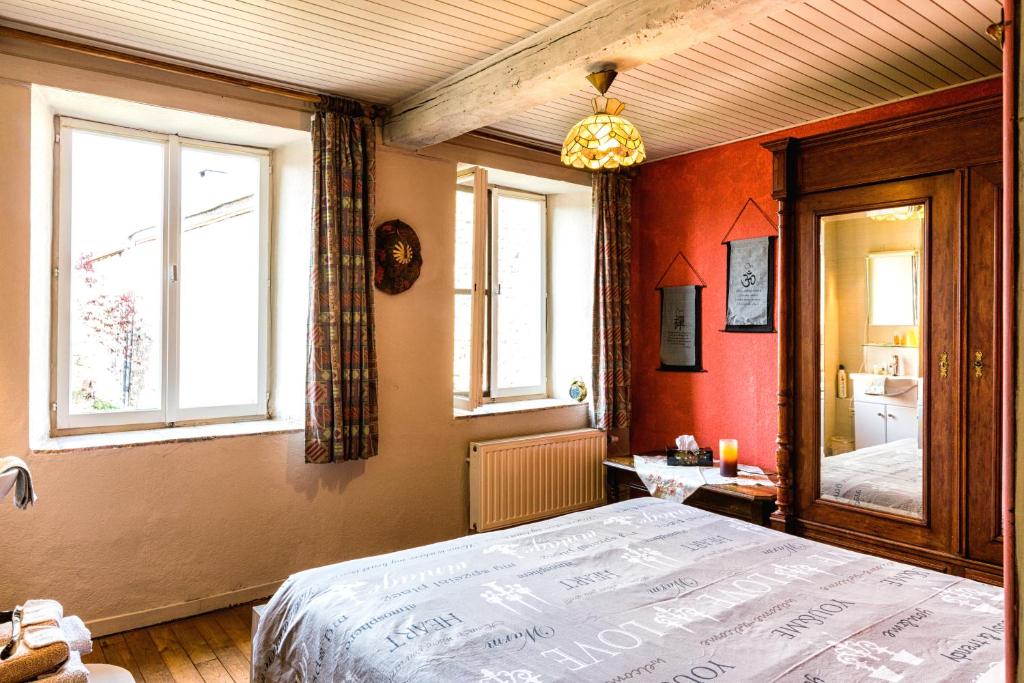 1 dormitorio con 1 cama y 2 ventanas en Relax à Maison Sax Kingsize, en Durbuy