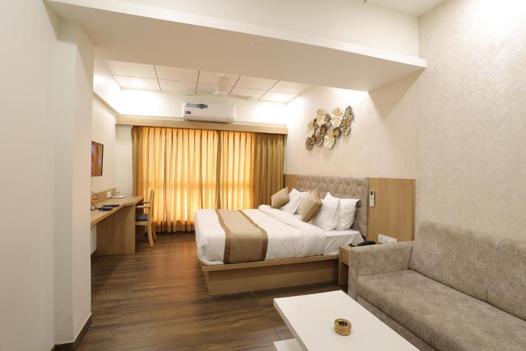 een hotelkamer met een bed en een bank bij Hotel PTC in Indore