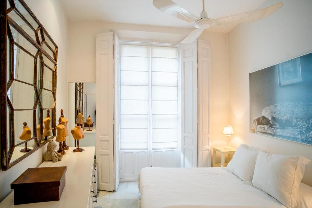 ein Schlafzimmer mit einem Bett und einem großen Fenster in der Unterkunft Eva Recommends Gamazo in Sevilla
