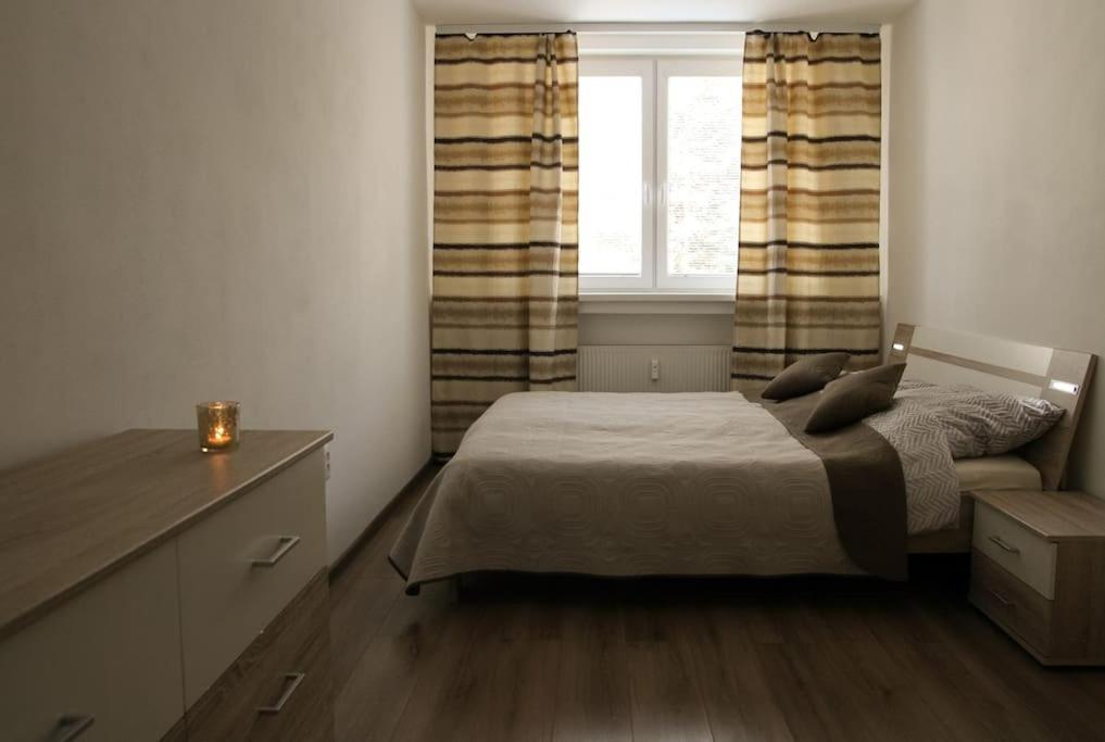 ein kleines Schlafzimmer mit einem Bett und einem Fenster in der Unterkunft Apartmán Roosevelt in Banská Bystrica