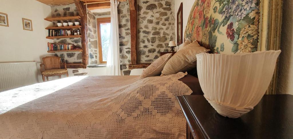 a bedroom with a bed with a white comforter at La chambre d&#39;hôte du Petit Mazilloux in Présailles