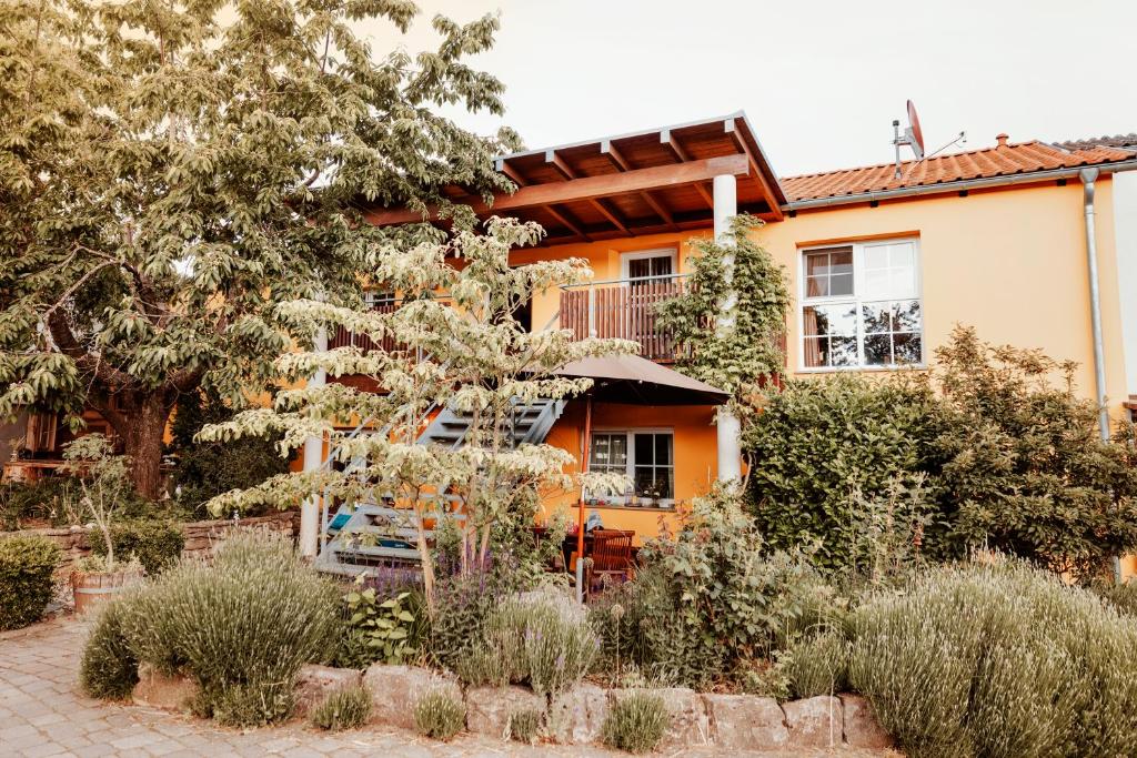 una casa naranja con un jardín delante de ella en Eventbauernhof Wendelinshof 