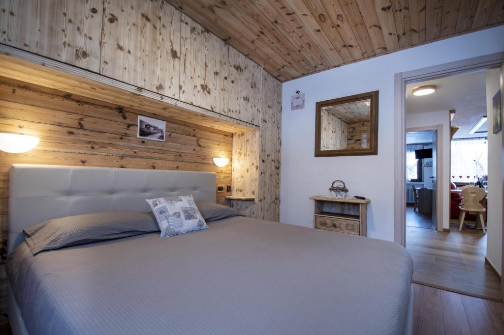 a bedroom with a bed and a wooden wall at Home, sweet home in Livigno