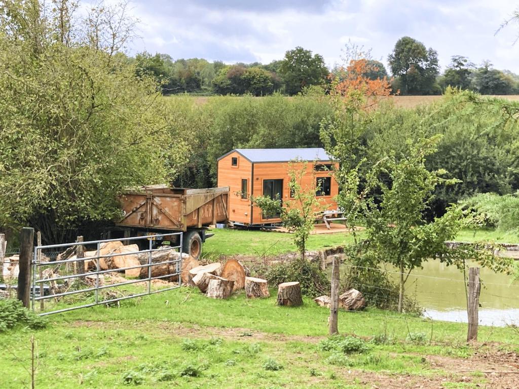 a tiny house with a truck in a field at Joy Tiny House in Saint-Germain-le-Vieux