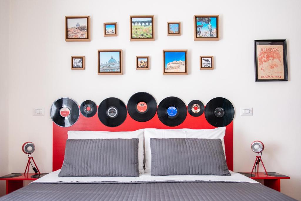 un dormitorio con una cama con un montón de discos en la pared en Grammy Suite, en Roma