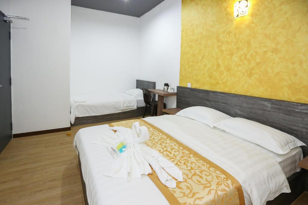 Postel nebo postele na pokoji v ubytování New Dawn Hotel Pontian Sdn Bhd